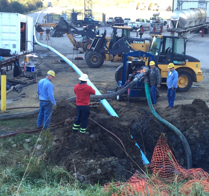 Workers operating machinery and equipment for coal ash dewatering at a construction site, with a focus on safety practices and initiatives.